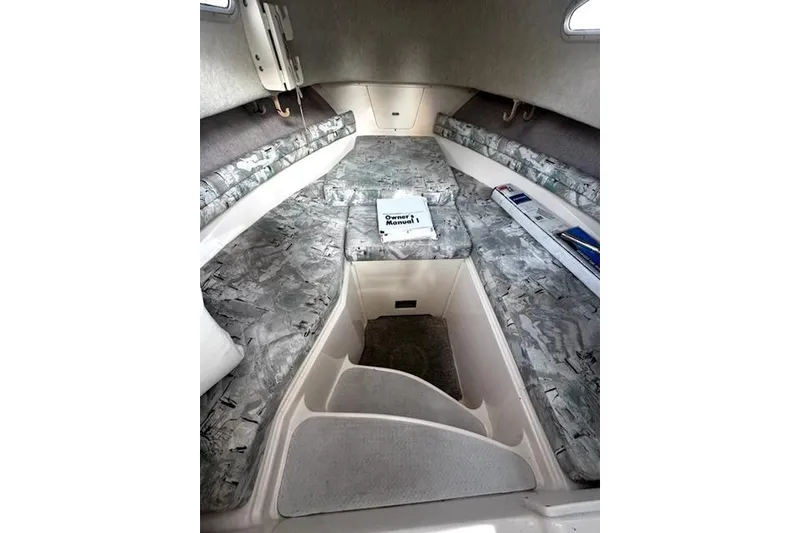 Slide: The Image of 1996 Grady-White Voyager 248 cabin interior with patterned seating and owner's manual. - 9