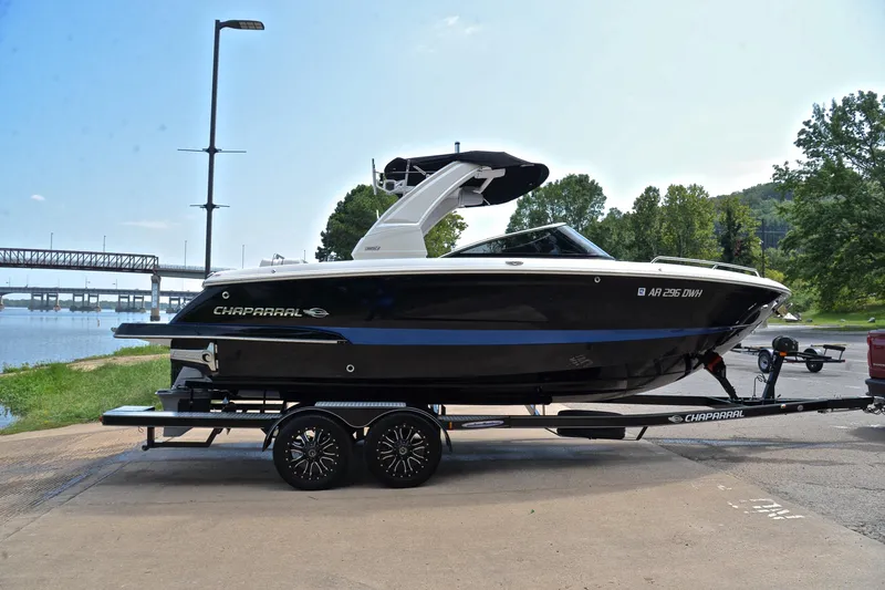 Slide: The Image of 2020 Chaparral 25 Surf boat on trailer by riverside, ready for adventure. - 17