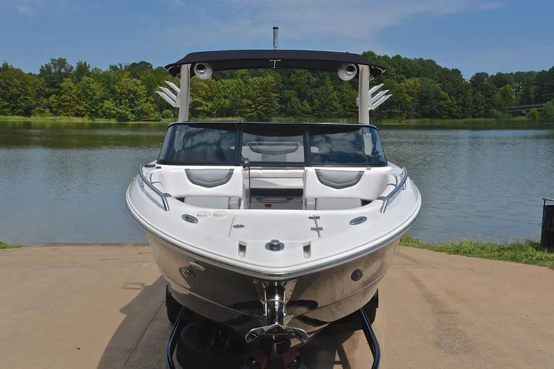 Slide: The Image of 2020 Chaparral 25 Surf boat on a lakefront, showcasing sleek design and modern features. - 19