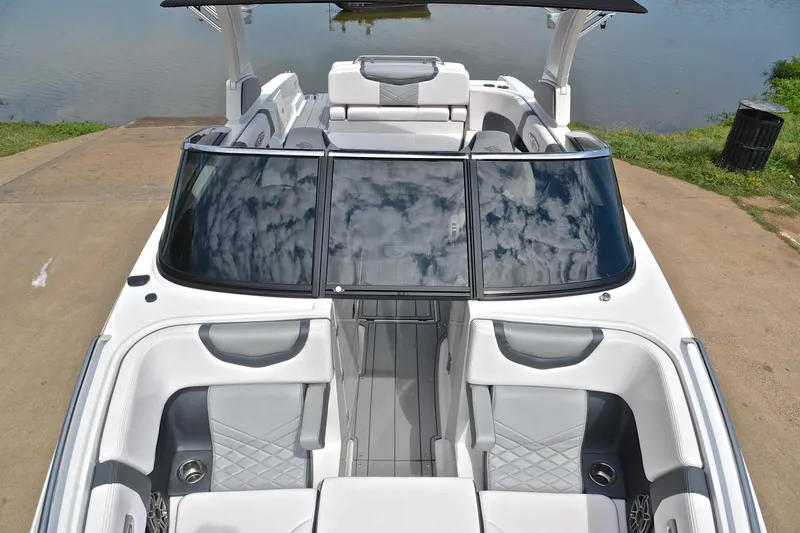 Slide: The Image of 2020 Chaparral 25 Surf boat with sleek design and spacious seating, docked by the water. - 22