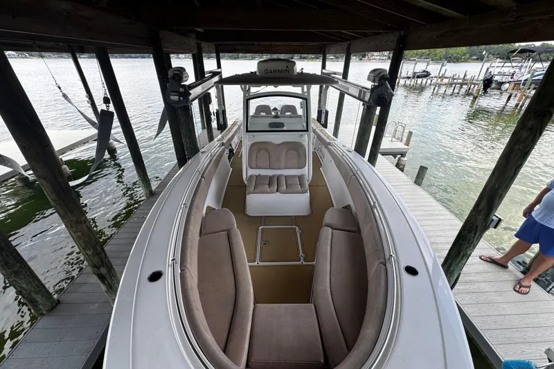 Slide: The Image of 2020 Sportsman Open 312 Center Console boat docked under a wooden shelter. - 12