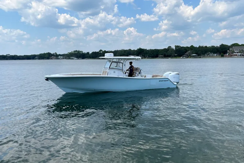 Slide: The Image of 2020 Sportsman Open 312 Center Console boat on calm water under a partly cloudy sky. - 2