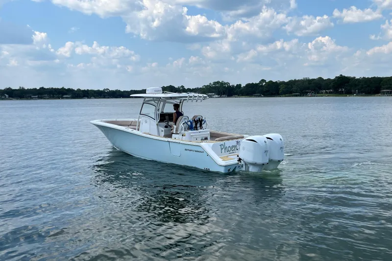 Slide: The Image of 2020 Sportsman Open 312 Center Console boat on calm lake under cloudy sky. - 3