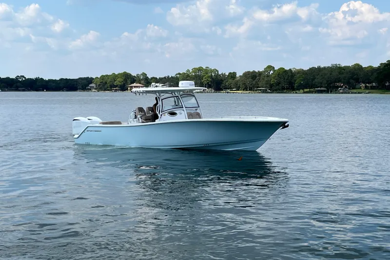 Slide: The Image of 2020 Sportsman Open 312 Center Console boat on a calm lake under a blue sky. - 8