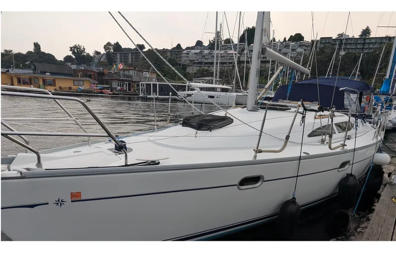 Slide: The Image of 2002 Jeanneau Sun Odyssey 37 sailboat docked in a marina, surrounded by other boats. - 0
