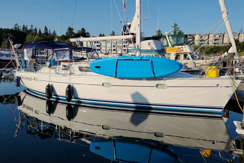 Slide: The Image of 2002 Jeanneau Sun Odyssey 37 sailboat docked with blue paddleboard on deck. - 1