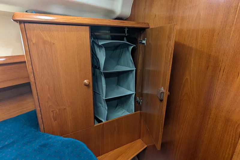 Slide: The Image of Wooden cabinet with fabric shelves inside a 2002 Jeanneau Sun Odyssey 37 sailboat. - 15