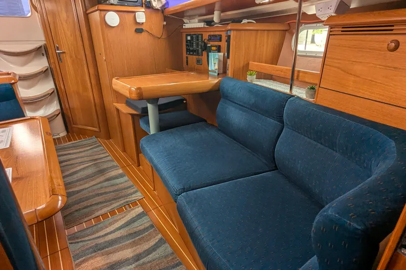 Slide: The Image of Interior of 2002 Jeanneau Sun Odyssey 37 yacht with blue seating and wooden finishes. - 16