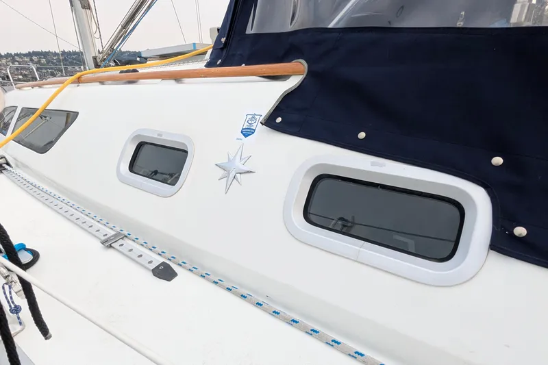 Slide: The Image of 2002 Jeanneau Sun Odyssey 37 sailboat deck with windows and navy cover. - 3