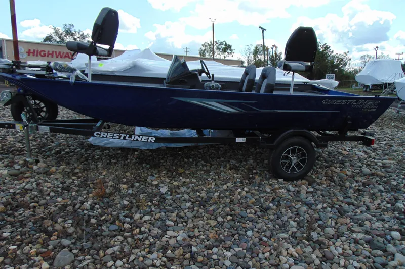 The Image of 2026 Crestliner 1700 Storm boat on trailer, parked on rocky ground. - 1