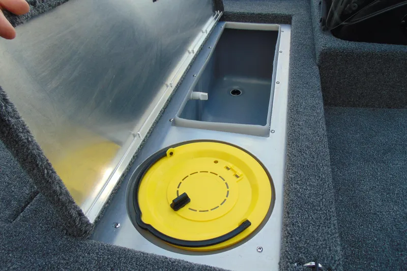 Slide: The Image of 2026 Crestliner 1700 Storm boat storage compartment with yellow lid and gray interior. - 9