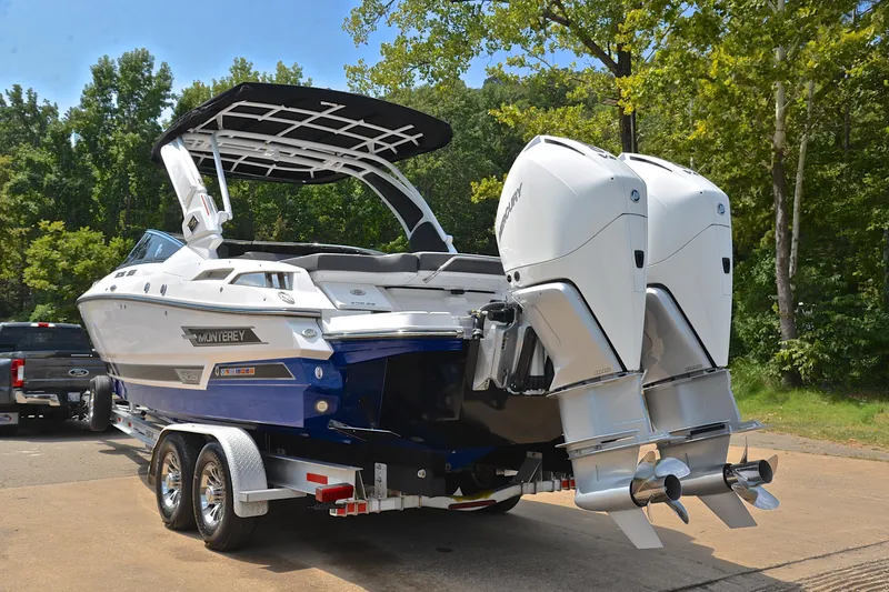 Slide: The Image of 2024 Monterey 305 Super Sport boat on trailer with dual engines, parked outdoors. - 14