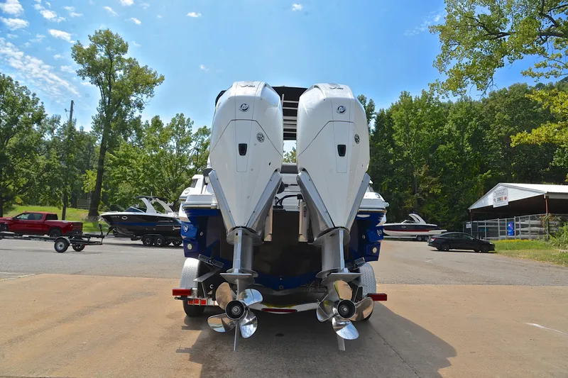 Slide: The Image of 2024 Monterey 305 Super Sport boat with dual outboard engines, parked outdoors. - 15
