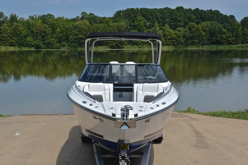 Slide: The Image of 2024 Monterey 305 Super Sport boat on trailer by a serene lake. - 19