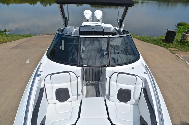 Slide: The Image of 2024 Monterey 305 Super Sport boat with sleek design and luxurious seating by the water. - 22