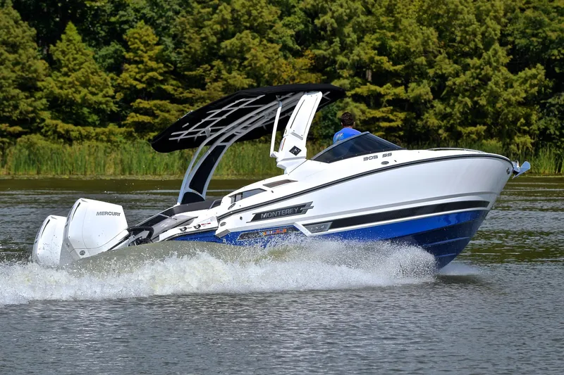 Slide: The Image of 2024 Monterey 305 Super Sport boat cruising on a lake with lush greenery. - 6