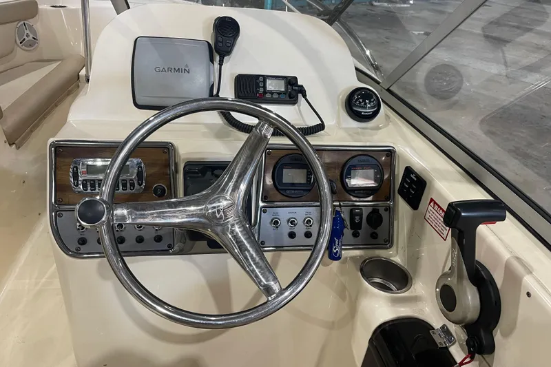Slide: The Image of 2008 Scout 242 Dorado boat dashboard with Garmin GPS, steering wheel, and control panel. - 11