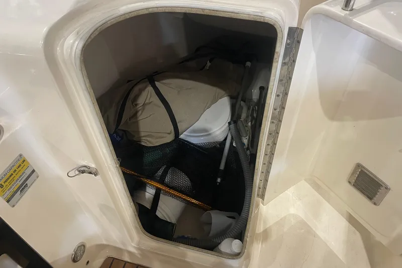 Slide: The Image of Storage compartment on a 2008 Scout 242 Dorado boat, containing various equipment. - 13