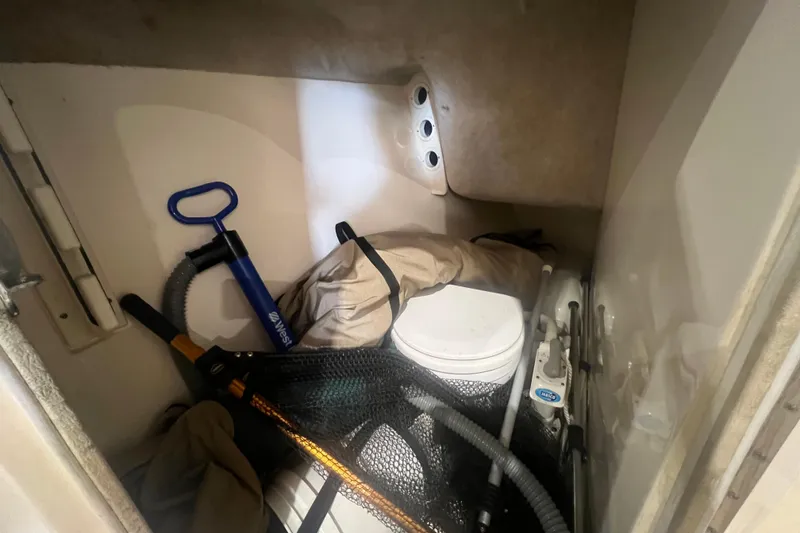 Slide: The Image of Storage compartment in a 2008 Scout 242 Dorado boat with various equipment. - 14