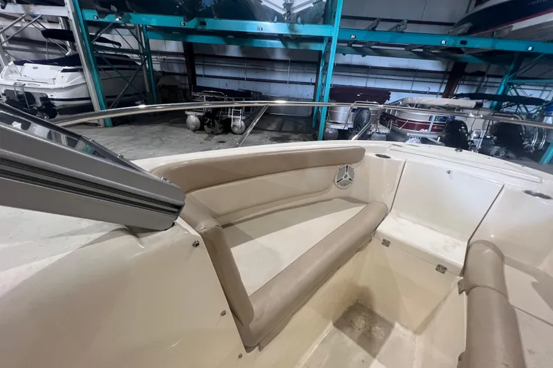 Slide: The Image of 2008 Scout 242 Dorado boat interior with beige seating in storage facility. - 16
