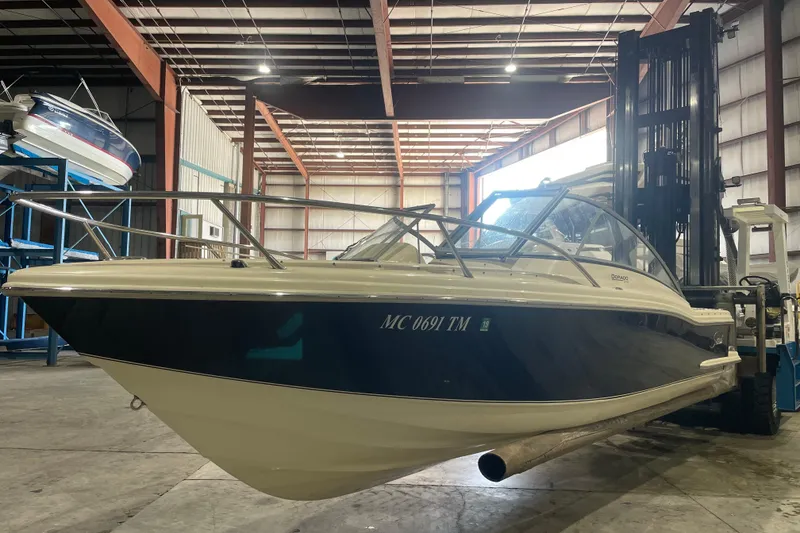 Slide: The Image of 2008 Scout 242 Dorado boat in warehouse, lifted by forklift. - 2