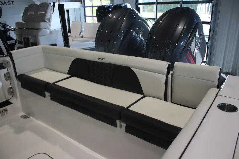 Slide: The Image of 2026 Tidewater 256 LXF boat interior with cushioned seating and dual outboard engines. - 15
