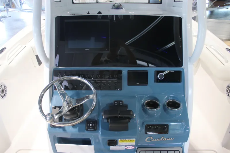 Slide: The Image of 2026 Tidewater 256 LXF boat dashboard with steering wheel and electronic controls. - 16