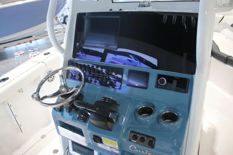 Slide: The Image of 2026 Tidewater 256 LXF boat dashboard with steering wheel and control panel. - 17