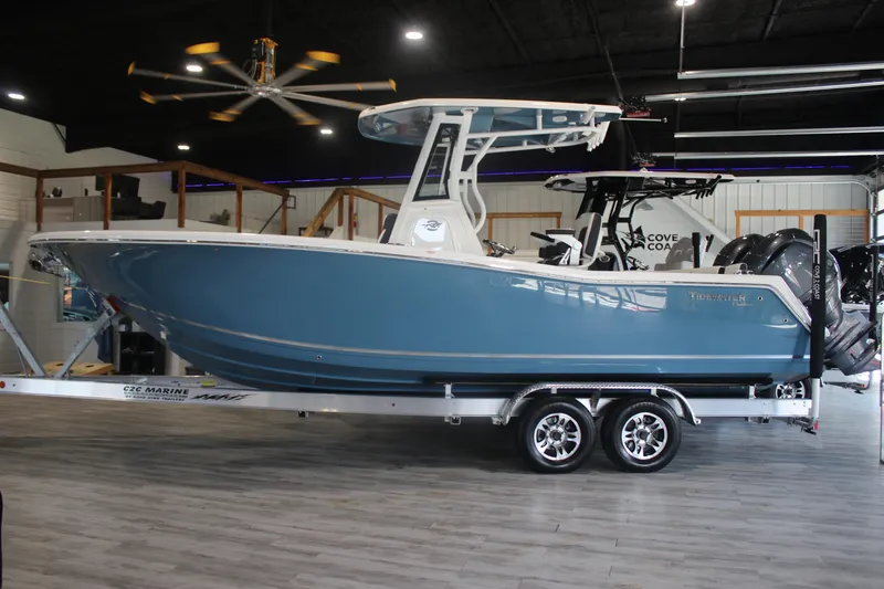 Slide: The Image of 2026 Tidewater 256 LXF boat in showroom, blue hull, on trailer. - 5