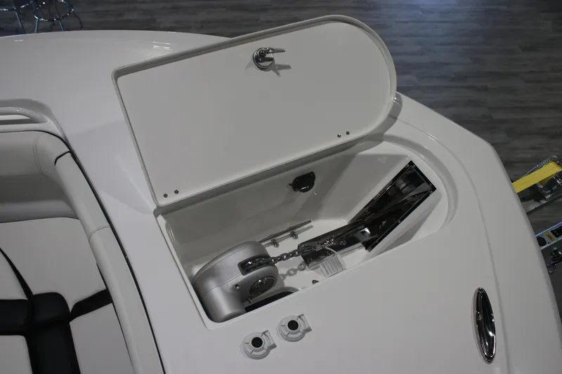 Slide: The Image of 2026 Tidewater 256 LXF boat anchor compartment with open hatch and visible chain. - 6