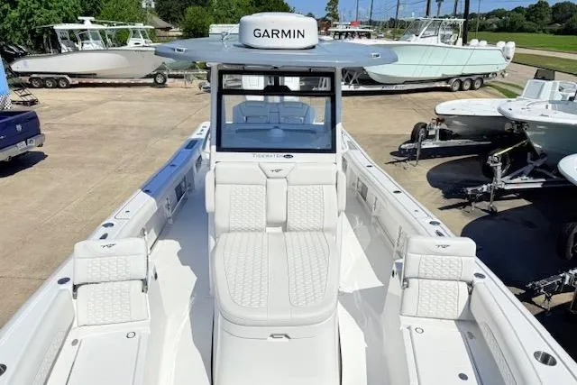 Slide: The Image of 2026 Tidewater 3100 Carolina Bay boat with Garmin equipment, docked in a marina. - 13