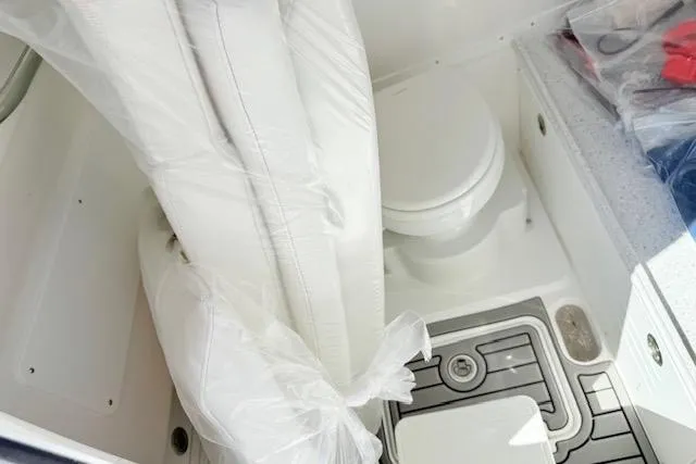 Slide: The Image of Interior of 2026 Tidewater 3100 Carolina Bay boat, featuring a compact marine toilet. - 14