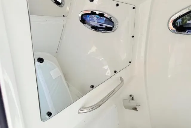 Slide: The Image of 2026 Tidewater 3100 Carolina Bay interior cabin with sleek white finish and porthole windows. - 16