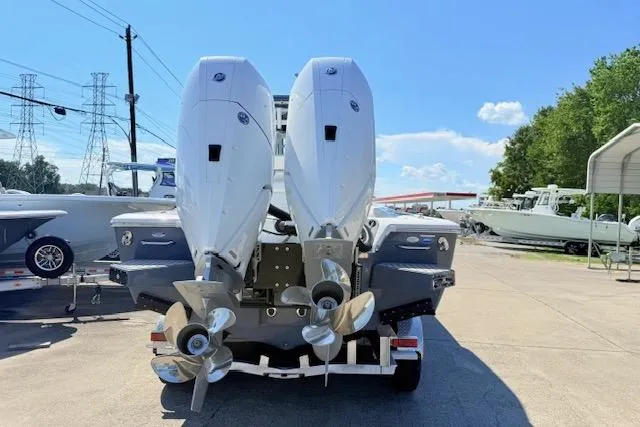 Slide: The Image of 2026 Tidewater 3100 Carolina Bay boat with dual outboard engines, parked outdoors. - 3