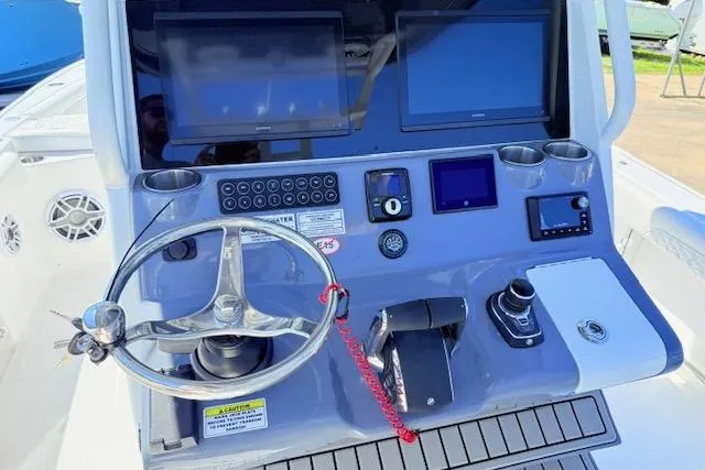Slide: The Image of 2026 Tidewater 3100 Carolina Bay boat dashboard with steering wheel and electronic displays. - 9