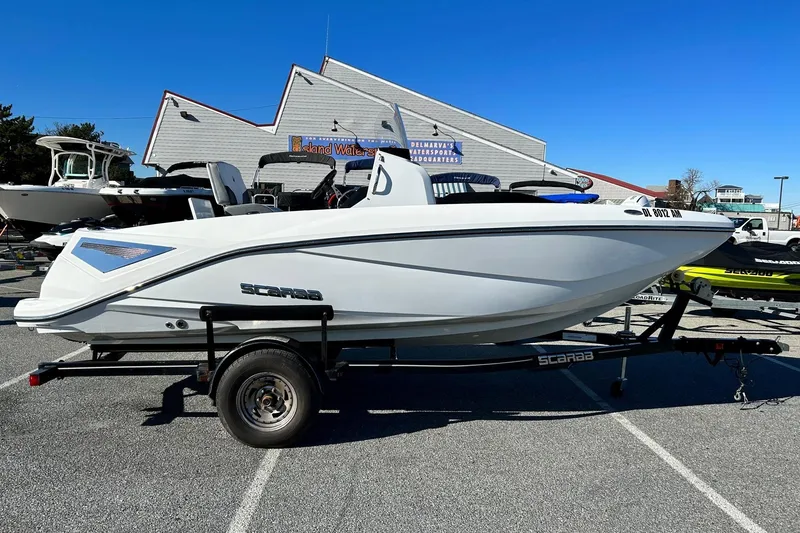 The Image of 2021 Scarab 195 ID boat on trailer, parked outdoors under clear blue sky. - 1