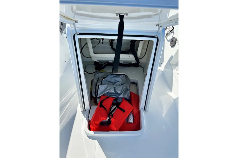 Slide: The Image of Open storage compartment in 2021 Scarab 195 ID boat with life jackets and gear. - 16