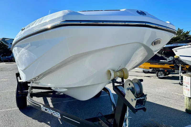 Slide: The Image of 2021 Scarab 195 ID boat on trailer, displayed outdoors under clear blue sky. - 3