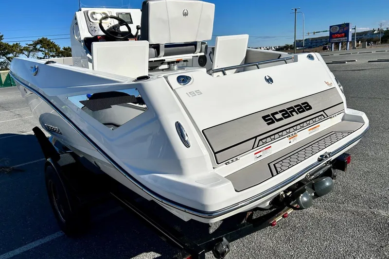Slide: The Image of 2021 Scarab 195 ID boat on trailer, rear view, white exterior, parked in a lot. - 9