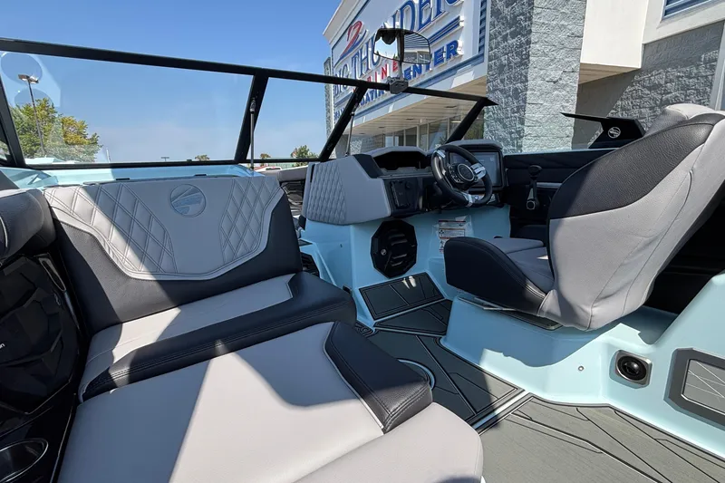 Slide: The Image of 2026 Tigé 24RZX boat interior with modern seating and dashboard, outside a dealership. - 21
