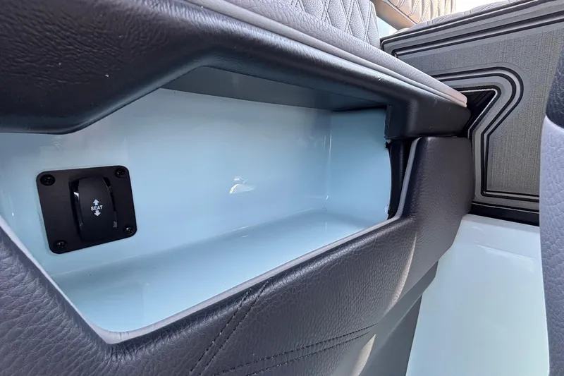 Slide: The Image of 2026 Tigé 24RZX boat interior storage compartment with seat adjustment control. - 26