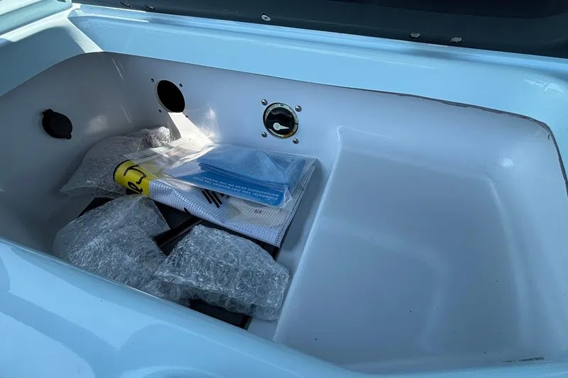 Slide: The Image of Storage compartment of 2026 Tigé 24RZX boat with bubble wrap and documents. - 35