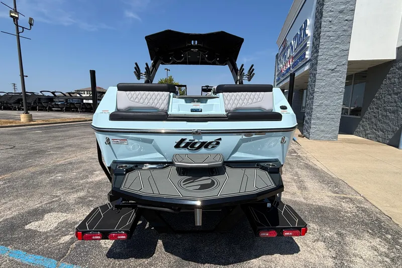 Slide: The Image of 2026 Tigé 24RZX boat, rear view, parked outside dealership on sunny day. - 4