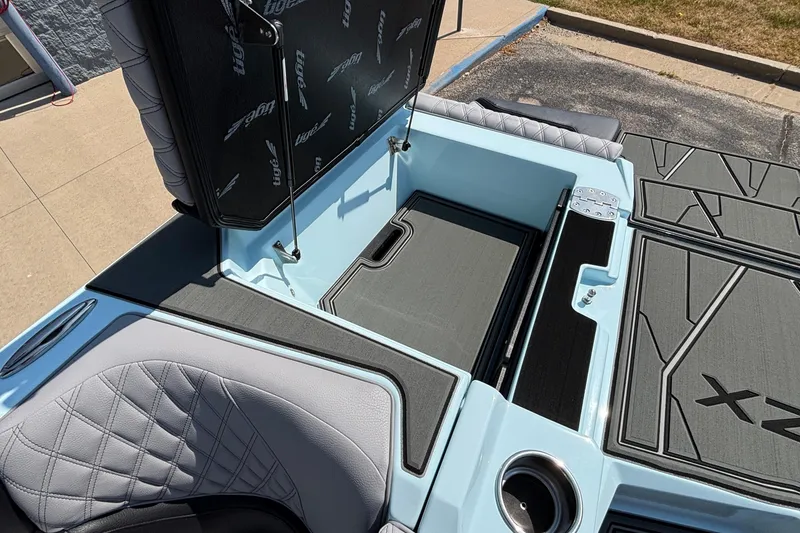 Slide: The Image of 2026 Tigé 24RZX boat interior with open storage compartment and quilted seating. - 42
