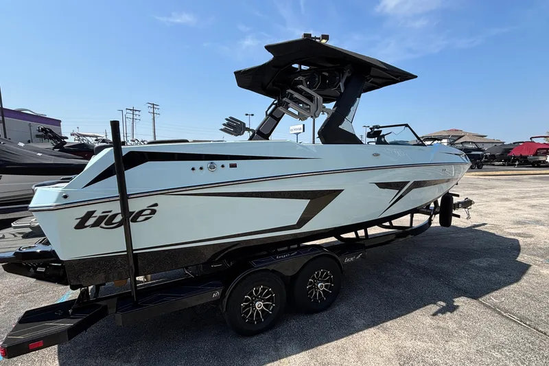 Slide: The Image of 2026 Tigé 24RZX boat on trailer, sleek design, parked outdoors under clear sky. - 6