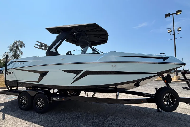 Slide: The Image of 2026 Tigé 24RZX boat on trailer, sleek design, parked outdoors under clear sky. - 7