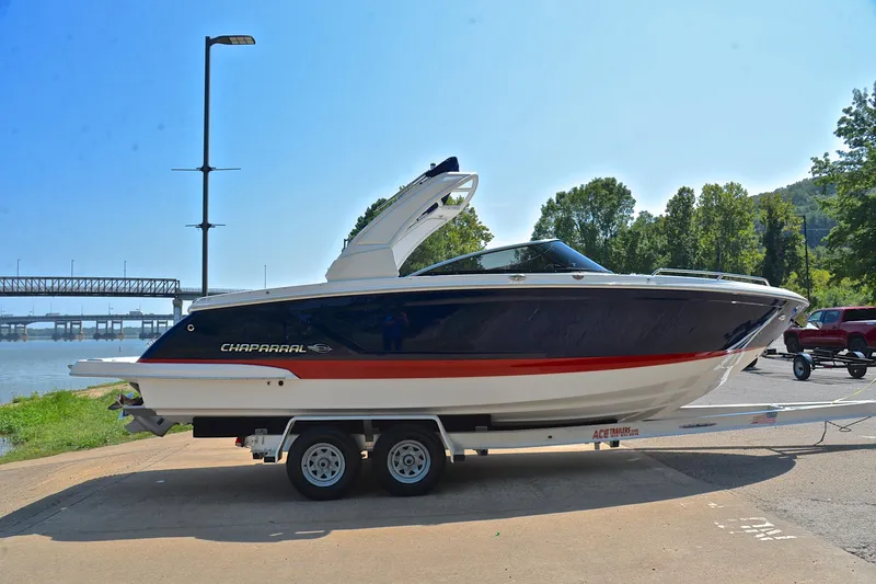 Slide: The Image of 2019 Chaparral 277 SSX boat on trailer by riverside, clear sky background. - 17