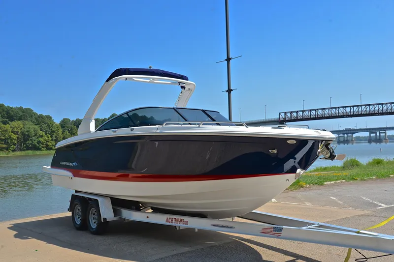 Slide: The Image of 2019 Chaparral 277 SSX boat on trailer by a river, clear blue sky. - 18