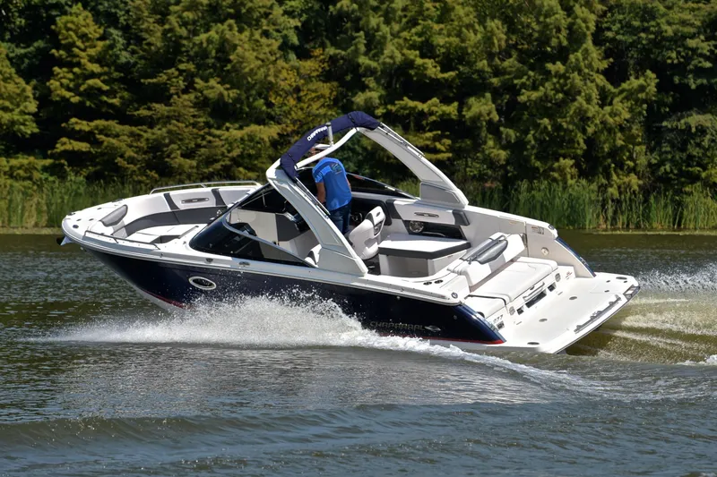 Slide: The Image of 2019 Chaparral 277 SSX boat cruising on a lake with lush greenery. - 6