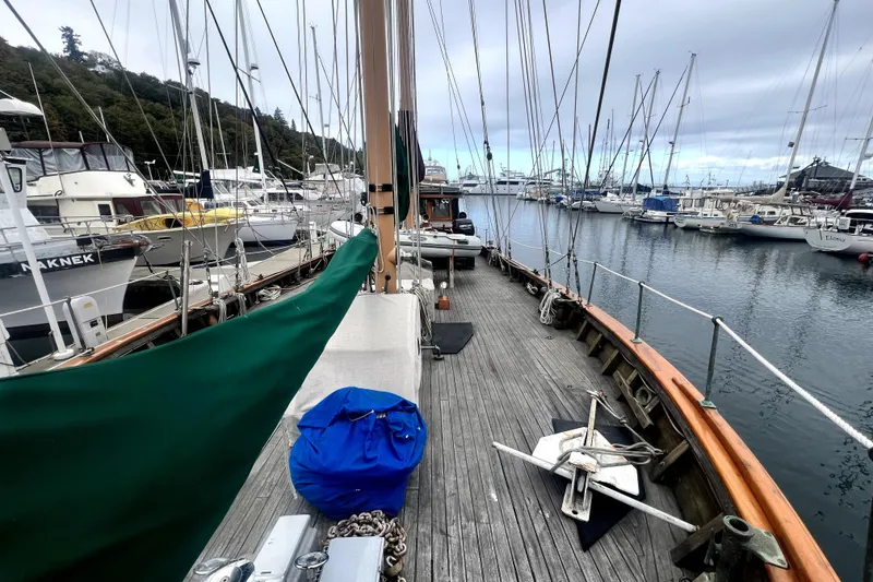 Slide: The Image of 1934 Pankey Schooner docked in a marina, surrounded by other sailboats. - 11